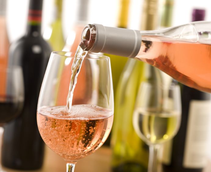 Wijnproeverij Amerongen wijn wordt ingeschonken vanuit fles in wijnglas Wijnproeverij Amerongen wijn wordt ingeschonken vanuit fles in wijnglas